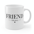 White mug with bold "FRIEND" text, "Est.2023" line, and heart icon