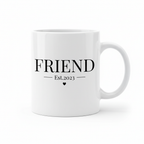 White mug with "FRIEND" lettering and "Est.2023" plus a small heart