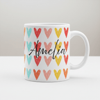 White mug with multicolor heart pattern and black cursive 'Amelia' on front
