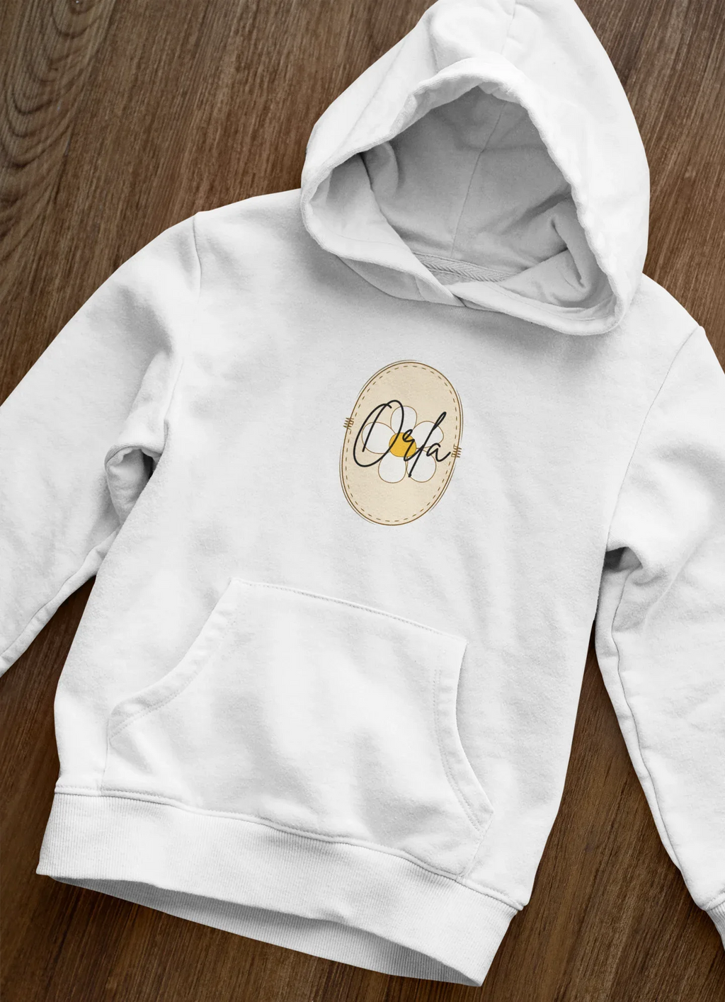 Kids white hoodie close-up with hood and front pocket; beige floral name badge logo