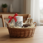White ceramic coffee mug with quote text in a basket with filler and red bow.