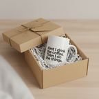 White ceramic coffee mug with humorous quote, packed in a gift box.