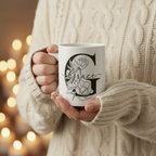 White personalized name mug held in hands with black floral design and “Grace”