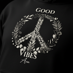 Close-up of black unisex hoodie fabric with 'Good Vibes' wreath graphic