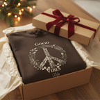 Dark unisex hoodie with 'Good Vibes' wreath graphic, shown with gift boxes