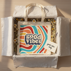 Top view of tote bag inside gift wrap, 'good vibes' logo on canvas front