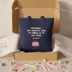 Navy tote bag with birthday cake graphic and text, shown in an open box