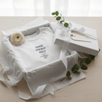White crew-neck T-shirt with “GOOD ENERGY ONLY” print, folded with ribbon and bow