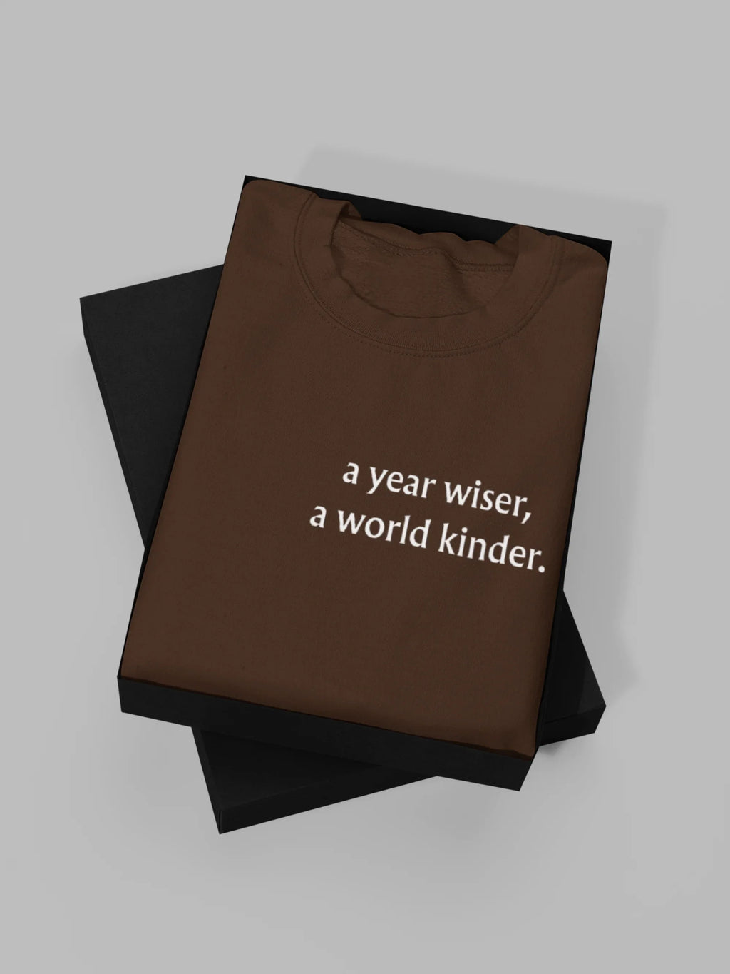 Brown crewneck sweatshirt with "a year wiser, a world kinder" text print