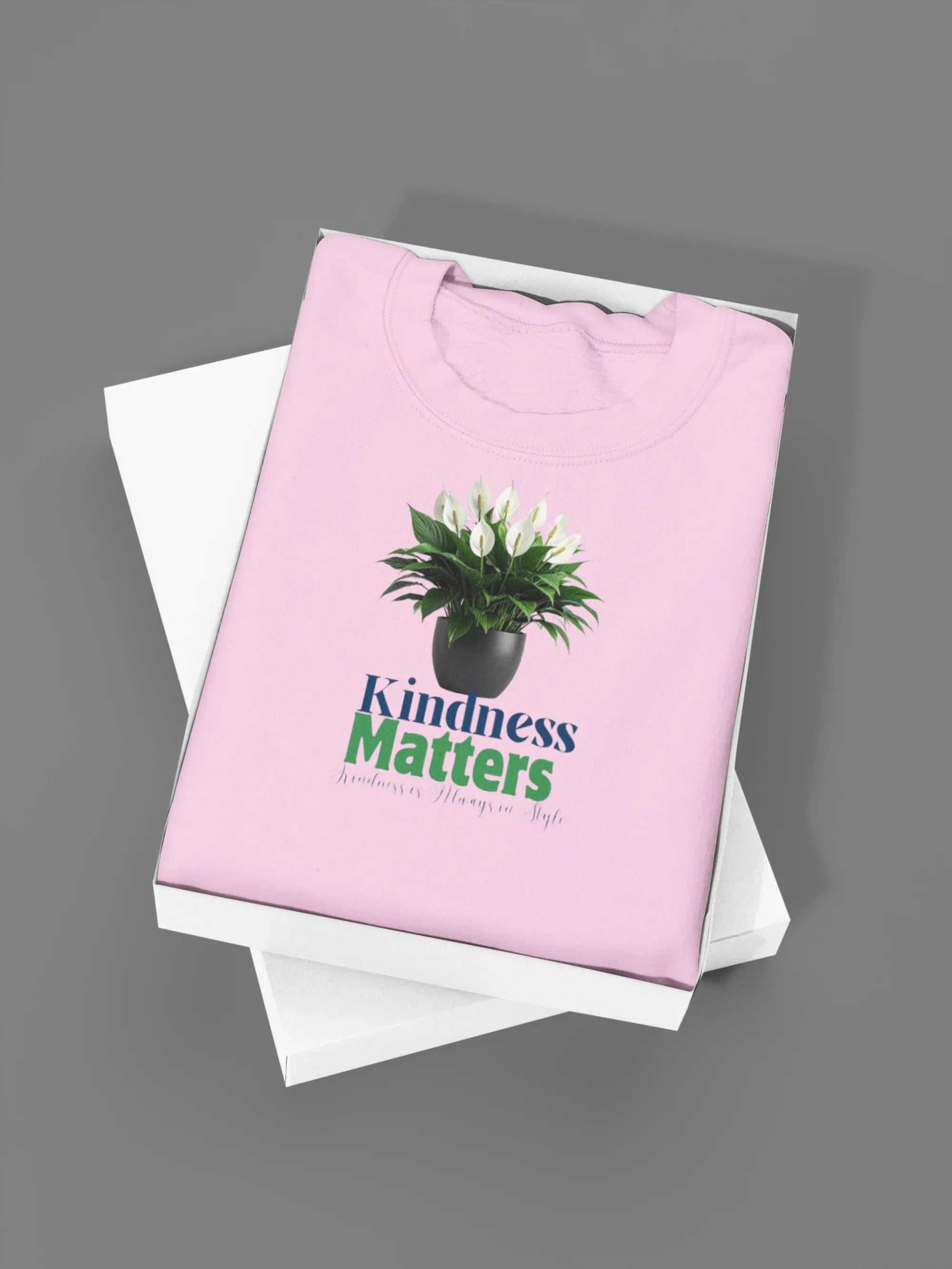 Light pink crewneck sweatshirt with tree graphic and “Kindness Matters” text on front