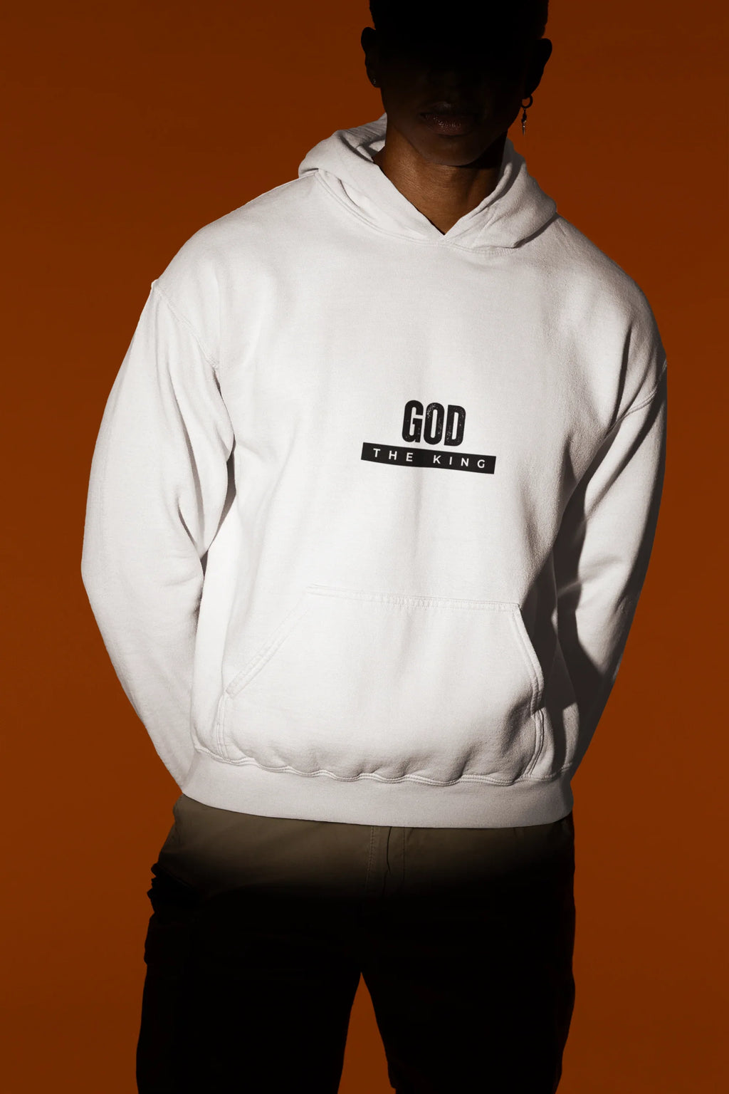 White hooded sweatshirt with front kangaroo pocket and 'GOD THE KING' chest graphic.