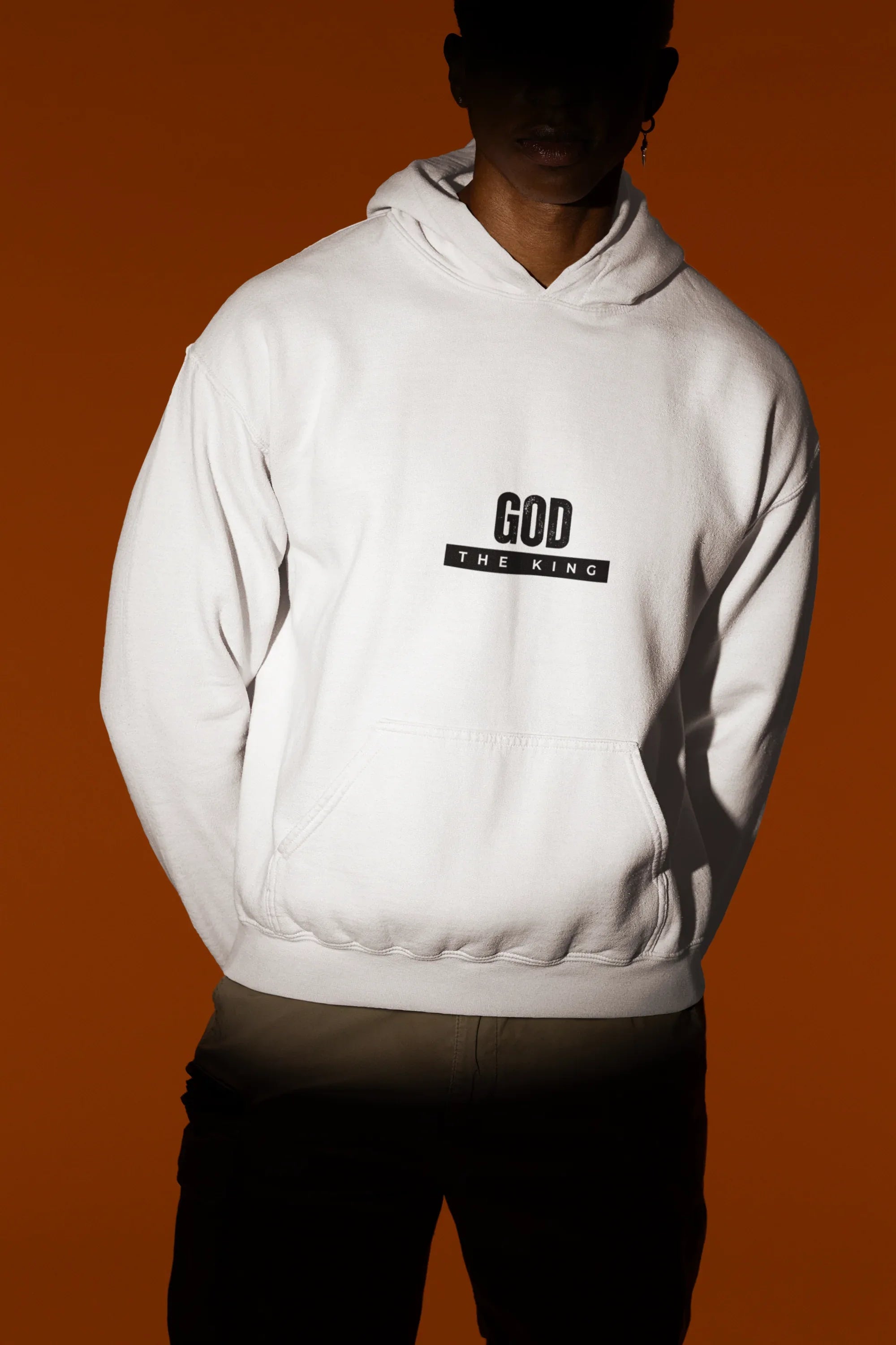 White hooded sweatshirt with front kangaroo pocket and 'GOD THE KING' chest graphic.