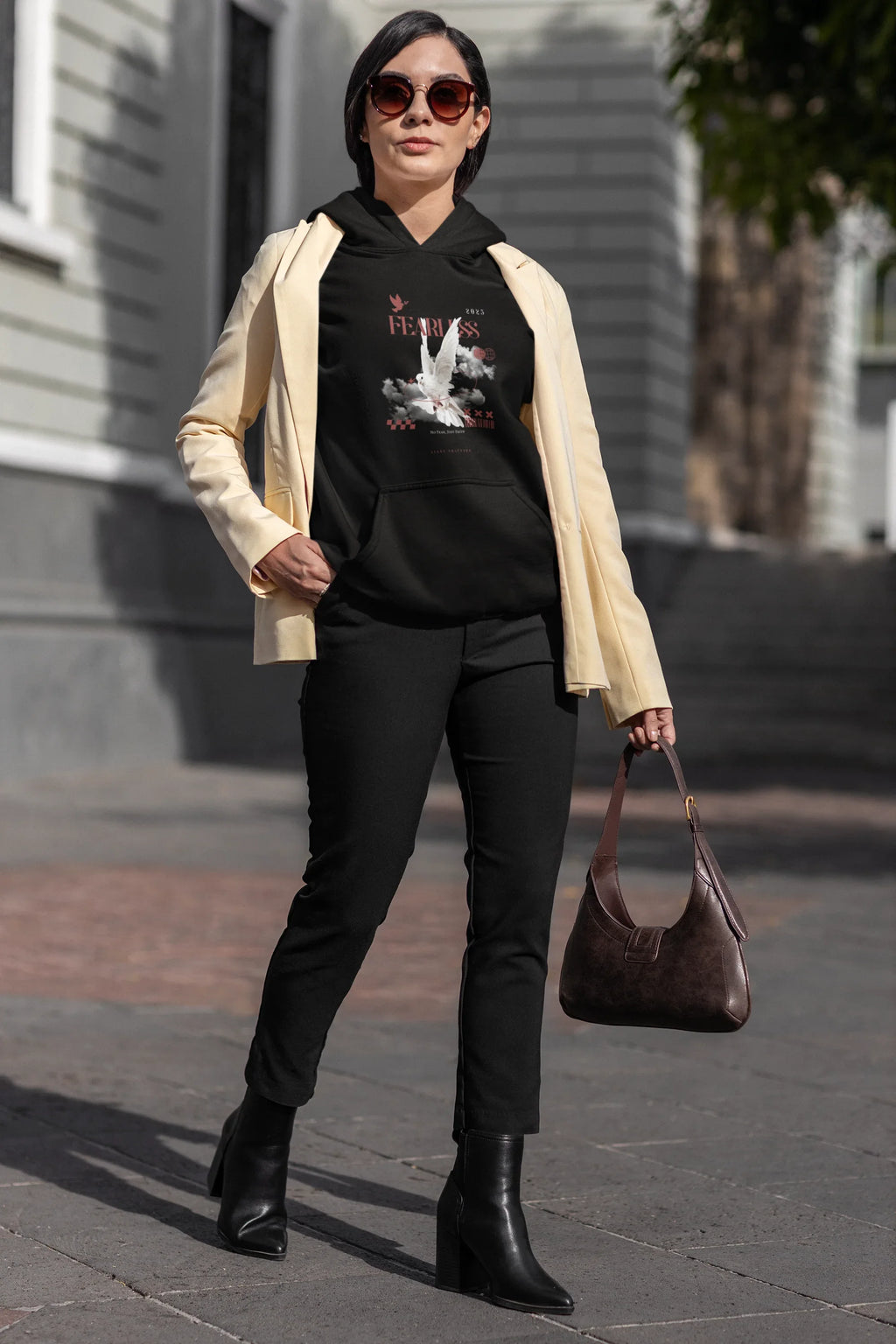 Black unisex hoodie with hood and front graphic, worn under light jacket
