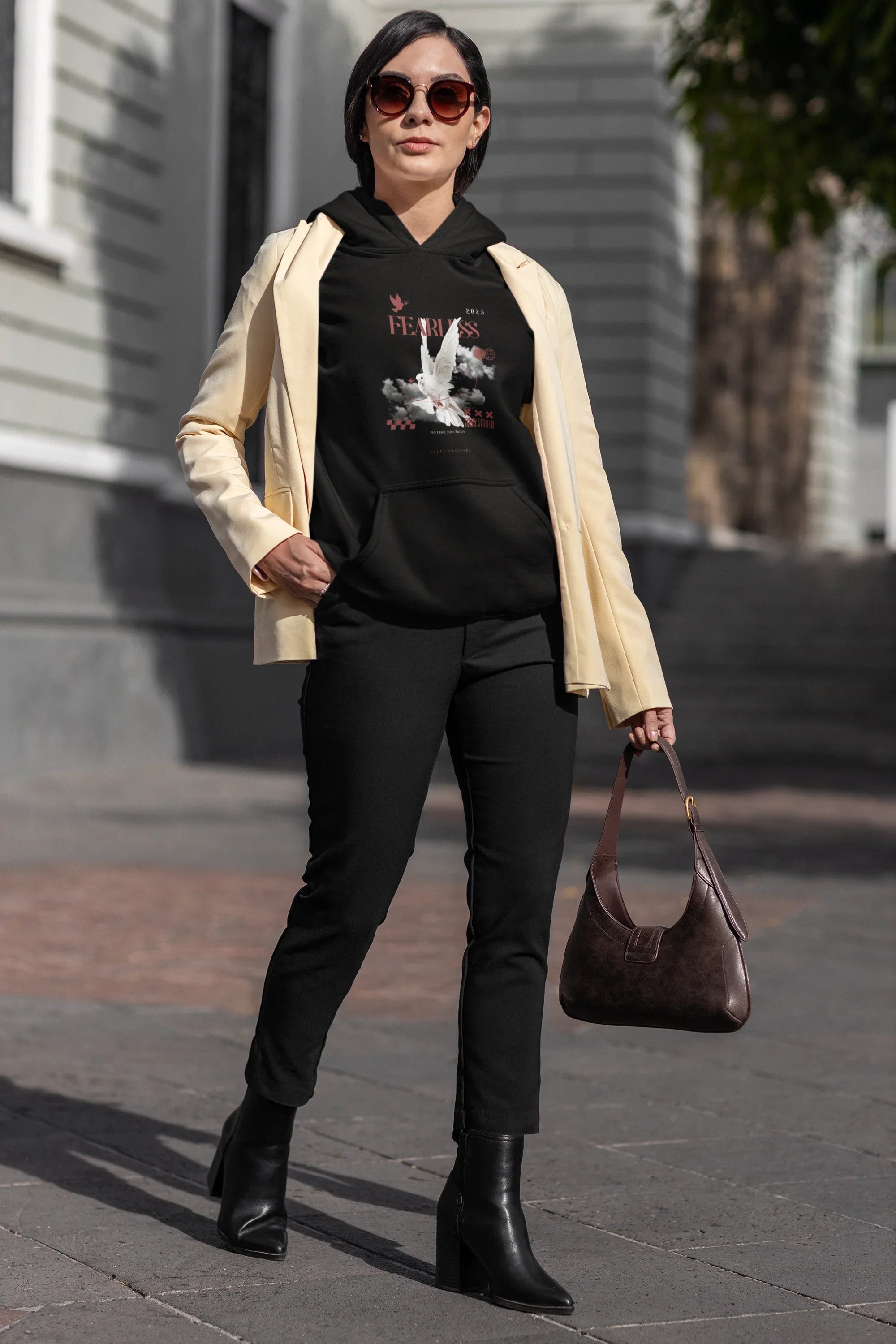 Black unisex hoodie with hood and front graphic, worn under light jacket
