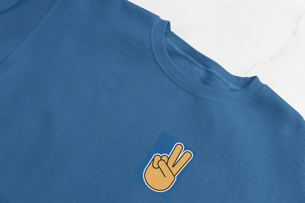 Royal blue sweatshirt detail: crew neck and embroidered peace hand on chest.