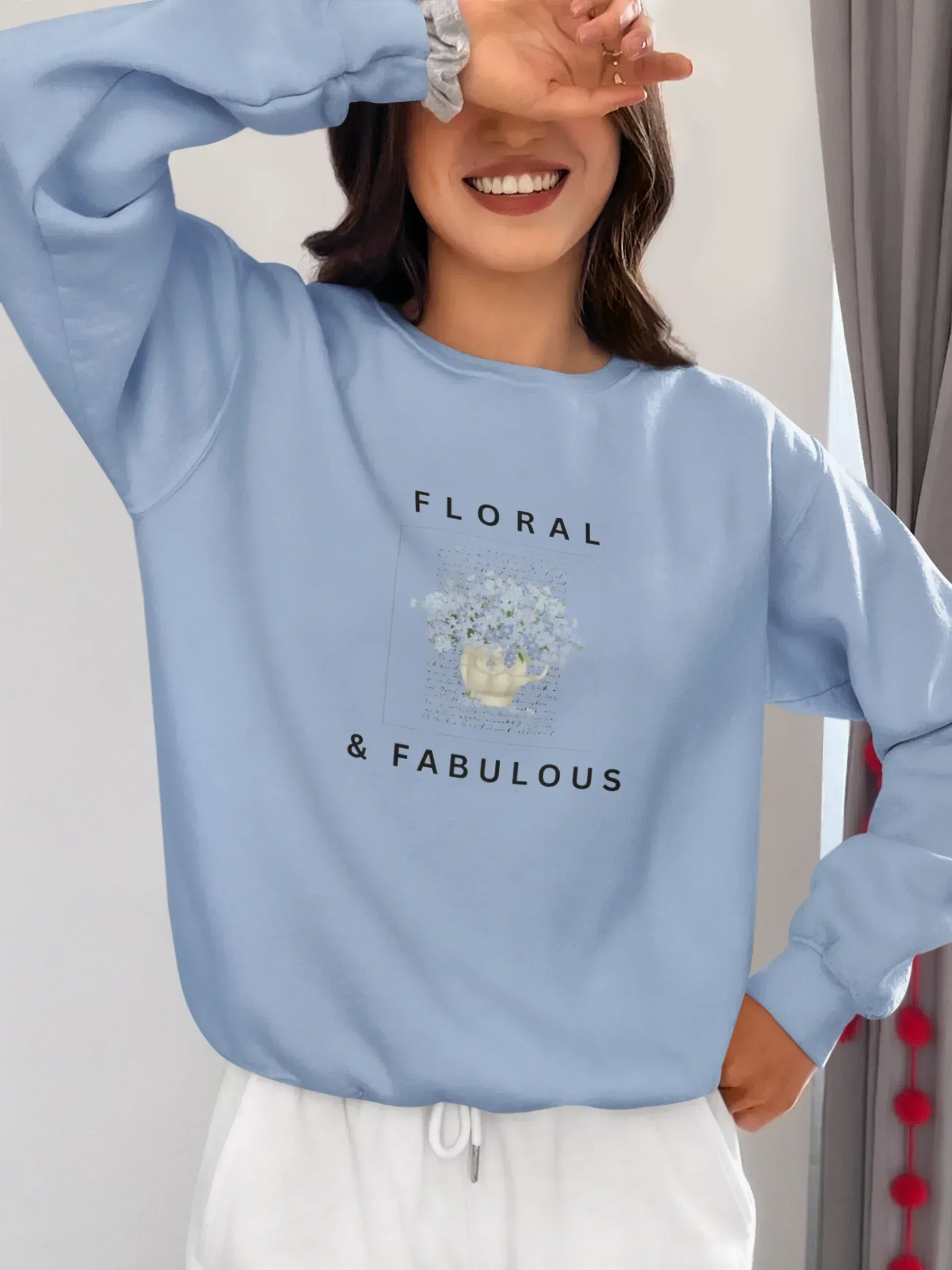 Light blue sweatshirt with floral graphic and "FLORAL" and "& FABULOUS" text