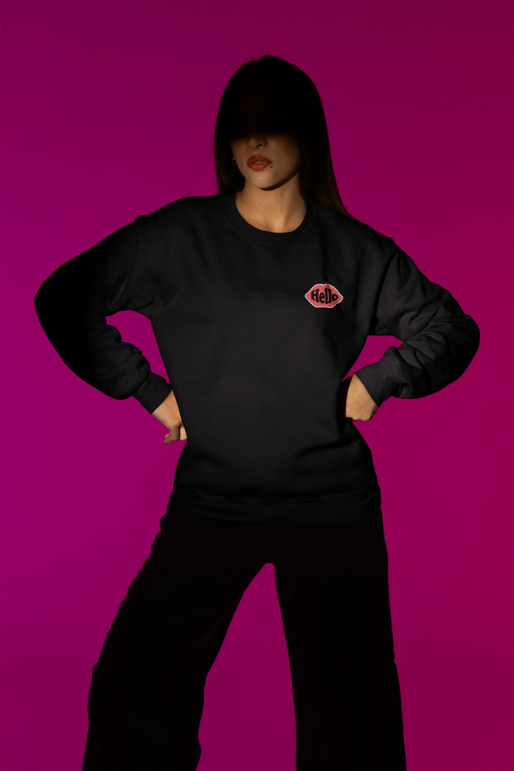 Black crewneck sweatshirt with embroidered lip logo on left chest.