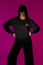 Black crewneck sweatshirt with embroidered lip logo on left chest.
