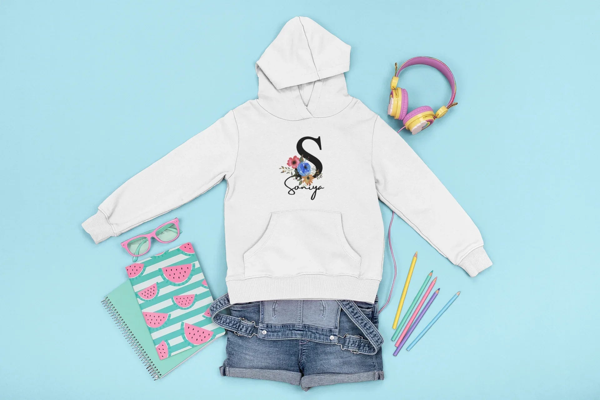 White kids hoodie with hood and front pocket, floral letter and script name graphic