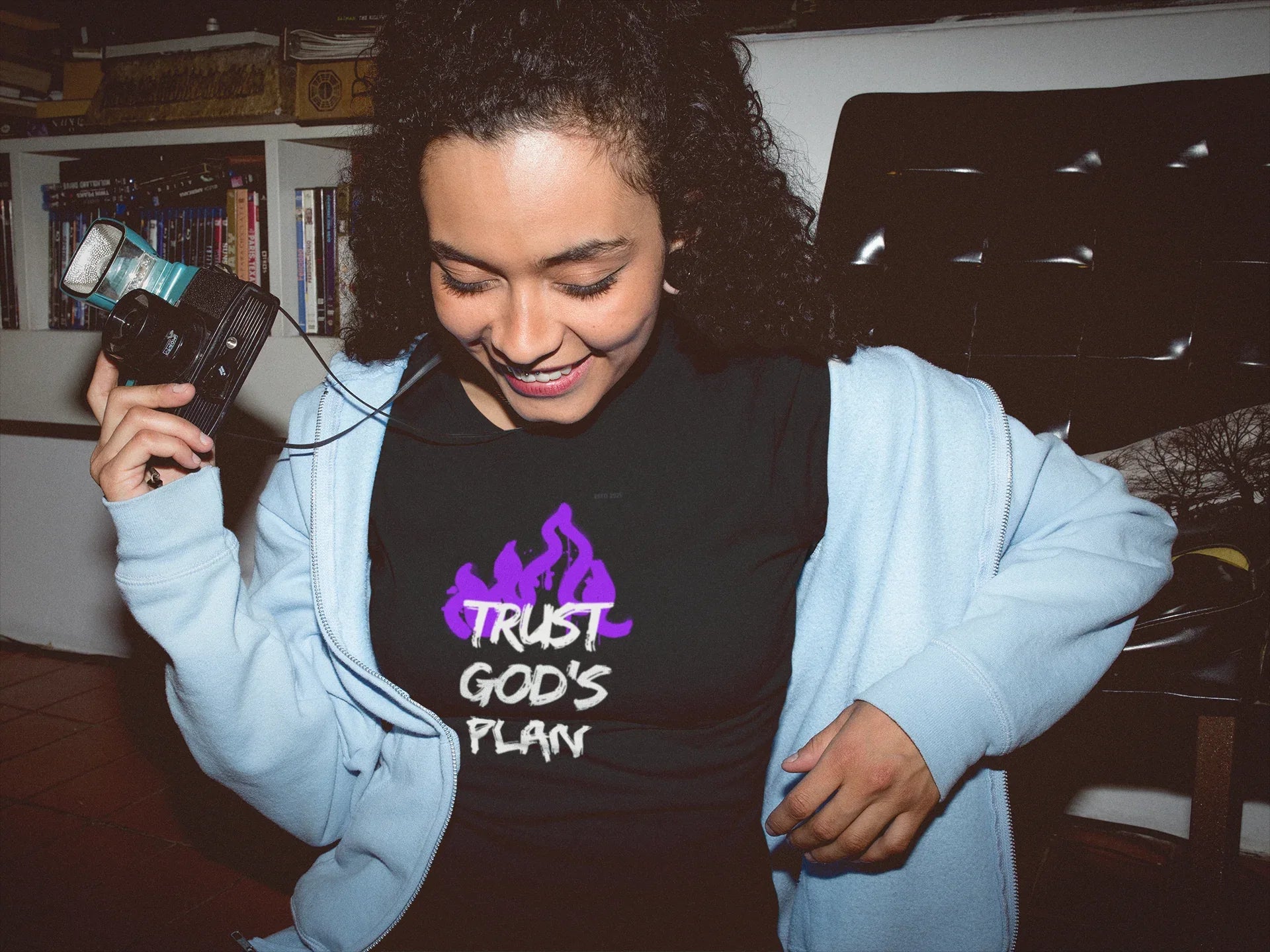 Light blue hoodie with front pouch pocket and purple flame-style text graphic.