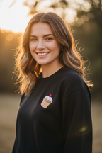 Black sweatshirt worn by person, with embroidered cupcake on the chest