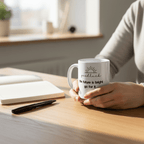 White coffee mug with 'good luck' quote and heart icon on a wooden tabletop