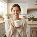 White coffee mug with 'good luck' quote and heart icon held by a smiling person