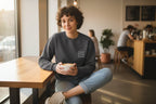 Charcoal crewneck sweatshirt with chest logo, worn