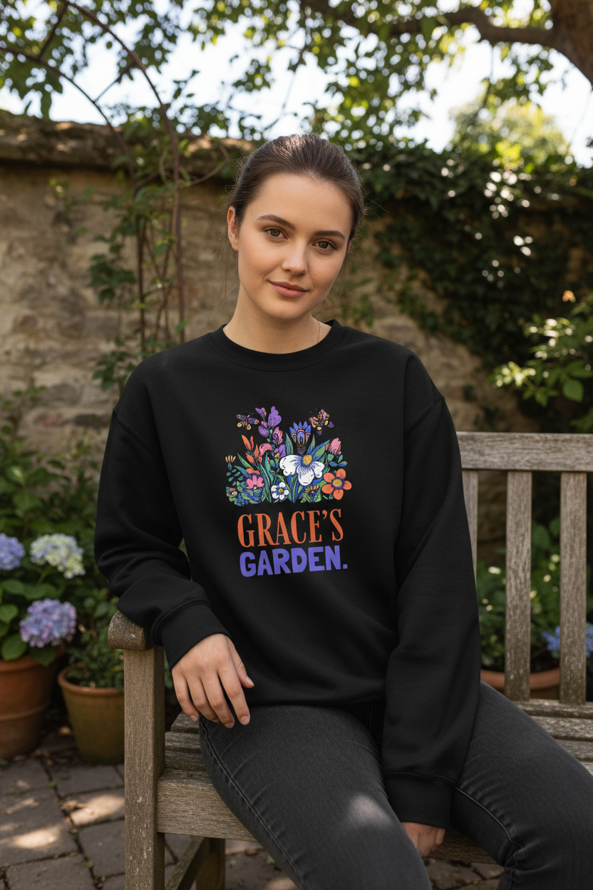 Personalized garden crewneck sweatshirt in black with floral graphic and “GRACE’S GARDEN” text.