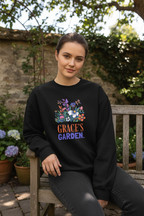 Personalized garden crewneck sweatshirt in black with floral graphic and “GRACE’S GARDEN” text.