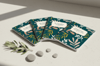 A5 spiral notebooks with teal botanical covers and beige title labels, arranged in a diagonal row.