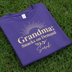 Purple T-shirt with gold “Grandma: Snacks on Demand” text and “Sarah”