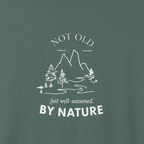 Dark green T-shirt with large centered mountain, trees, and 'BY NATURE' print