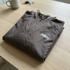 Folded gray hooded windbreaker jacket with Alley logo