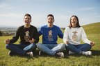 Sloth graphic sweatshirts in black, blue, and white worn by three people