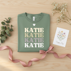 Personalised name stack T-shirt, sage green, heart above stacked 'KATIE' letters