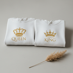 White hooded sweatshirt pair with gold Queen and King crown logos, folded front
