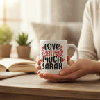 White mug with “Love you much SARAH” print in red hearts and black letters