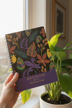 A5 notebook held in hand showing colorful leaf pattern cover and purple title band