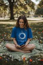 Blue graphic T-shirt with sun-and-moon emblem print on the chest.