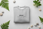 Heather gray crewneck sweatshirt with 'planet over profit' text and small heart