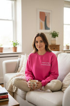 Pink crewneck sweatshirt with long sleeves and visible chest quote print
