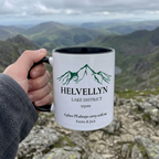 Helvellyn mug held against Lake District-style mountain scenery, personalised with Emma & Jack
