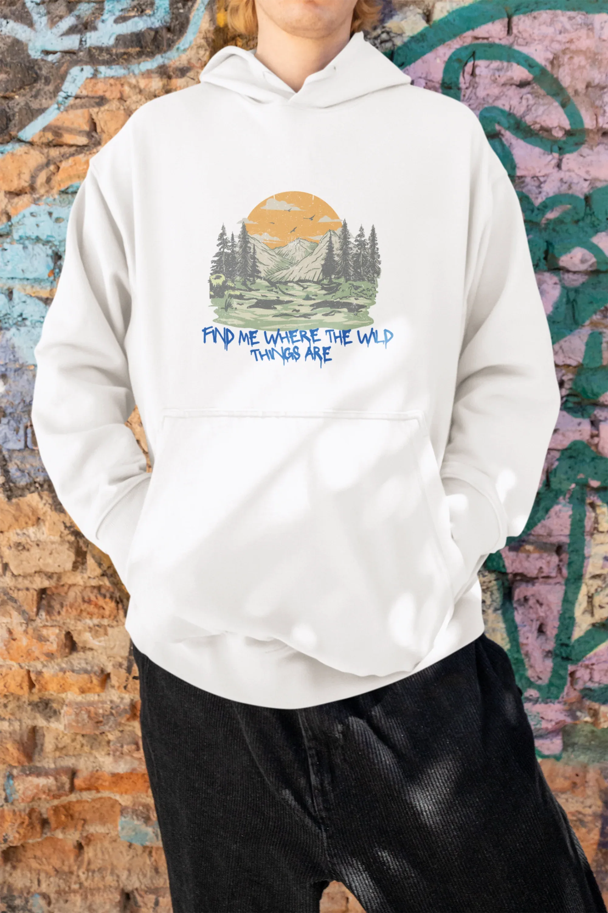White hoodie on model, hooded front with mountain forest and orange sun graphic