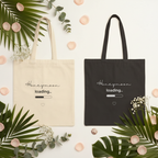 Canvas tote bags laid flat with Honeymoon loading... print and heart, natural and black
