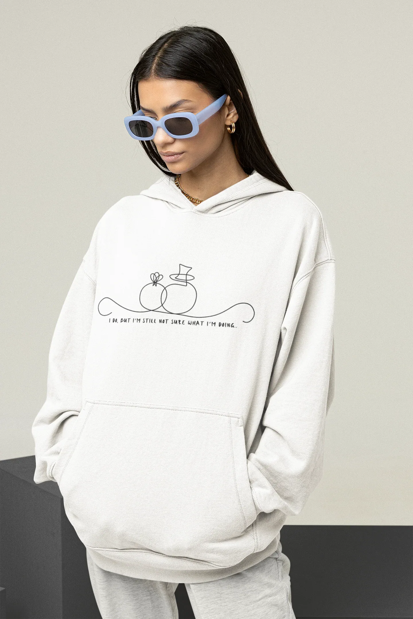 White unisex hoodie worn with hood and front pocket; line-art wedding rings graphic on chest.