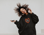 Black unisex hooded hoodie with orange flame logo on chest and drawstring hood