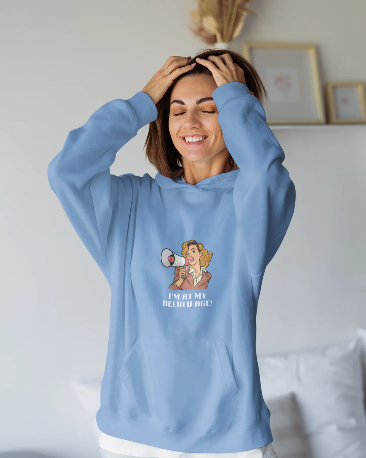 Light blue hooded sweatshirt worn by model with woman megaphone graphic