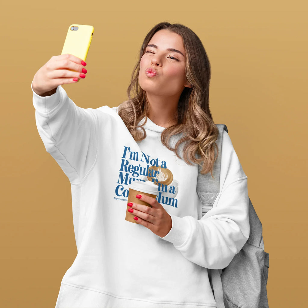 White hoodie sweatshirt with hood, kangaroo pocket, and coffee-themed “Not a Regular Mum” print
