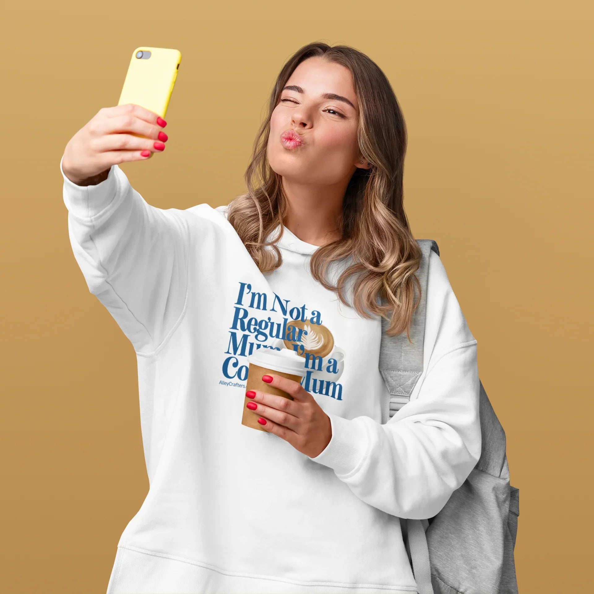 White hoodie sweatshirt with hood, kangaroo pocket, and coffee-themed “Not a Regular Mum” print